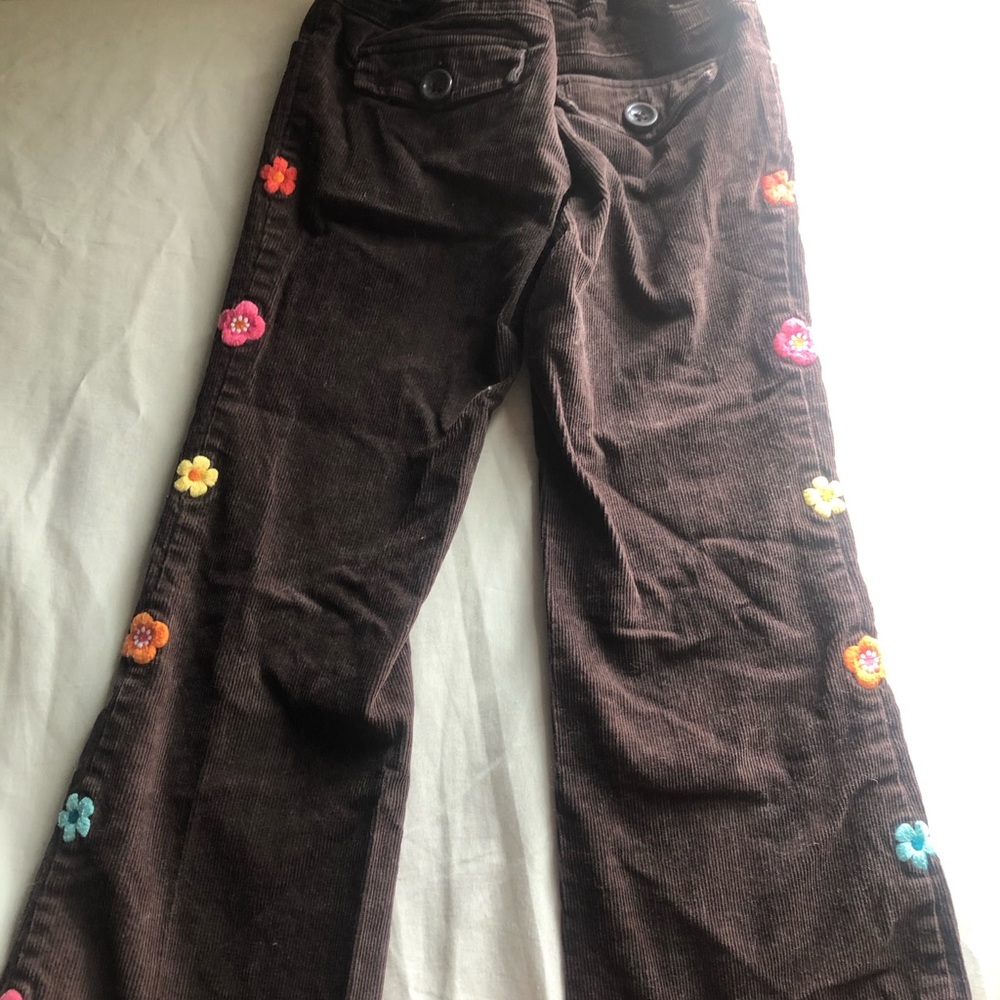 Brown Corduroy jeans with flowers on the sides.